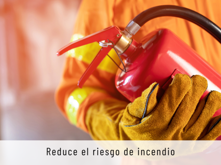 Extintor en mano, con guantes protectores, enfatizando la prevención de incendios.