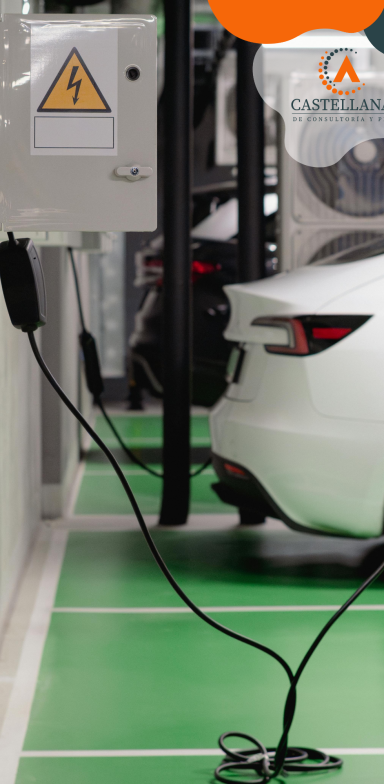 Coche eléctrico conectado a un cargador en un aparcamiento. Suelo verde.