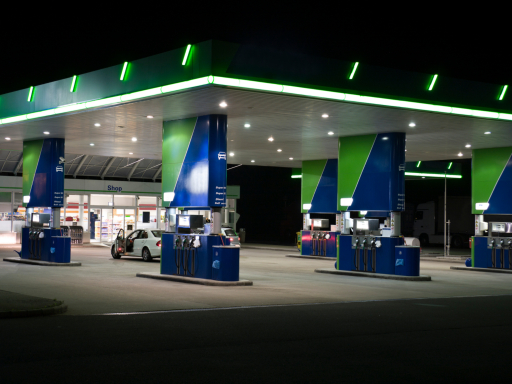 Estación de servicio iluminada por la noche con surtidores de combustible.